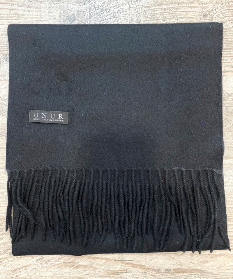 Lay-flat close up of black unisex woven cashmere scarf with tassles