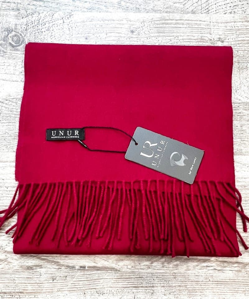 Lay-flat close up of burgundy unisex woven cashmere scarf with tassles