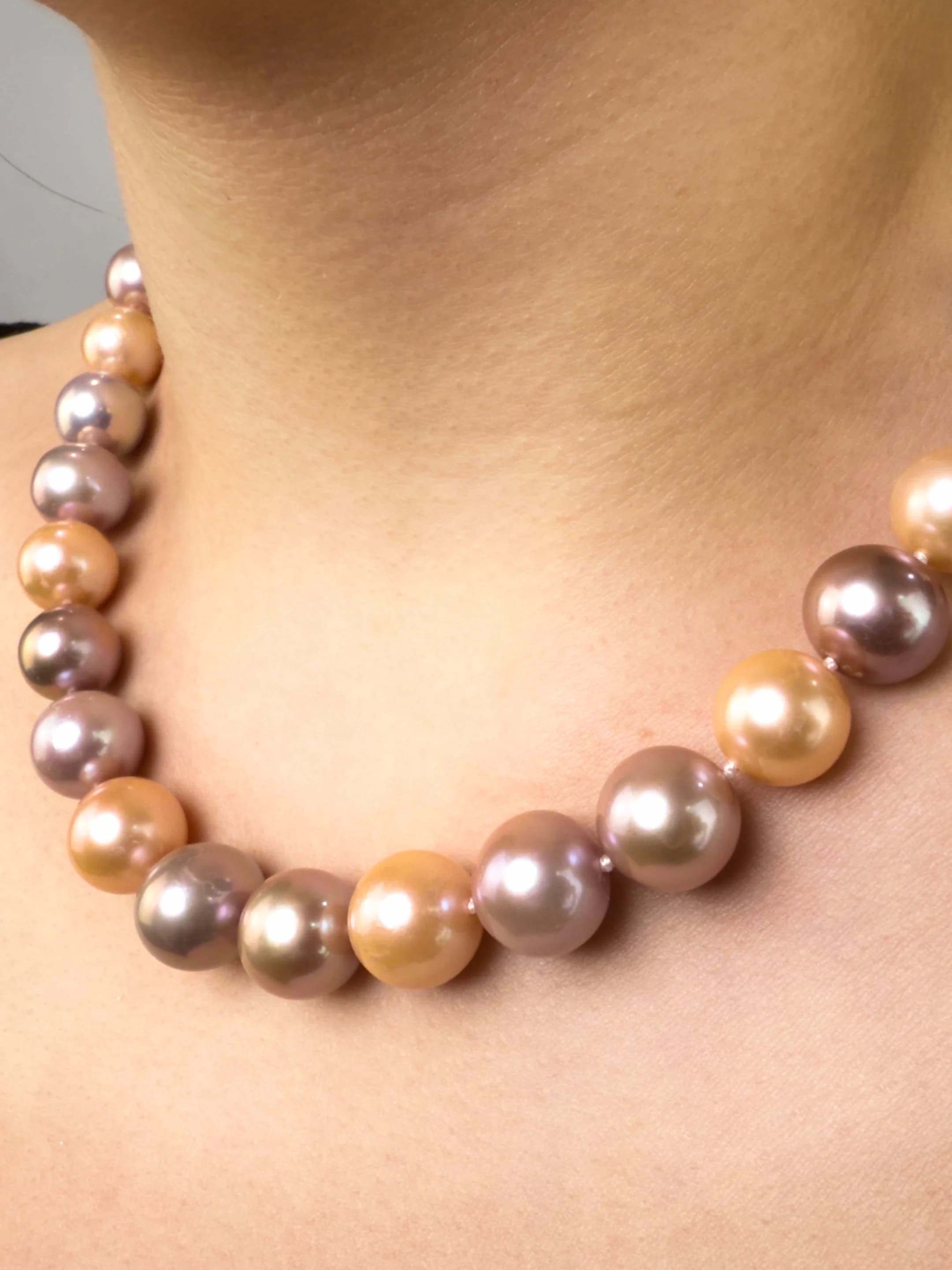 Model wearing classic necklace with peach and purple round pearls